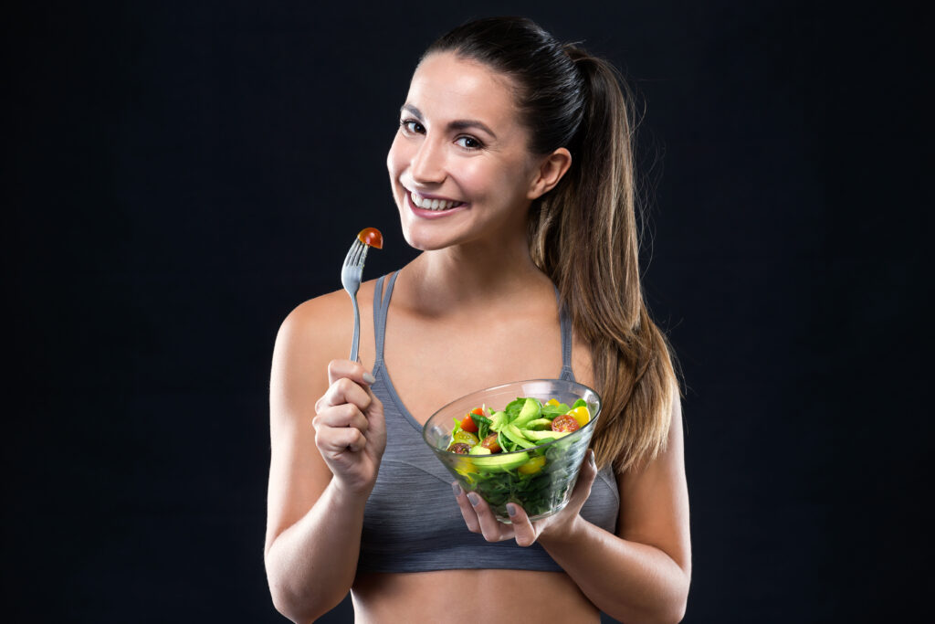 Healthy Eating Tips for Busy Lives 2 beautiful young woman eating salad black background