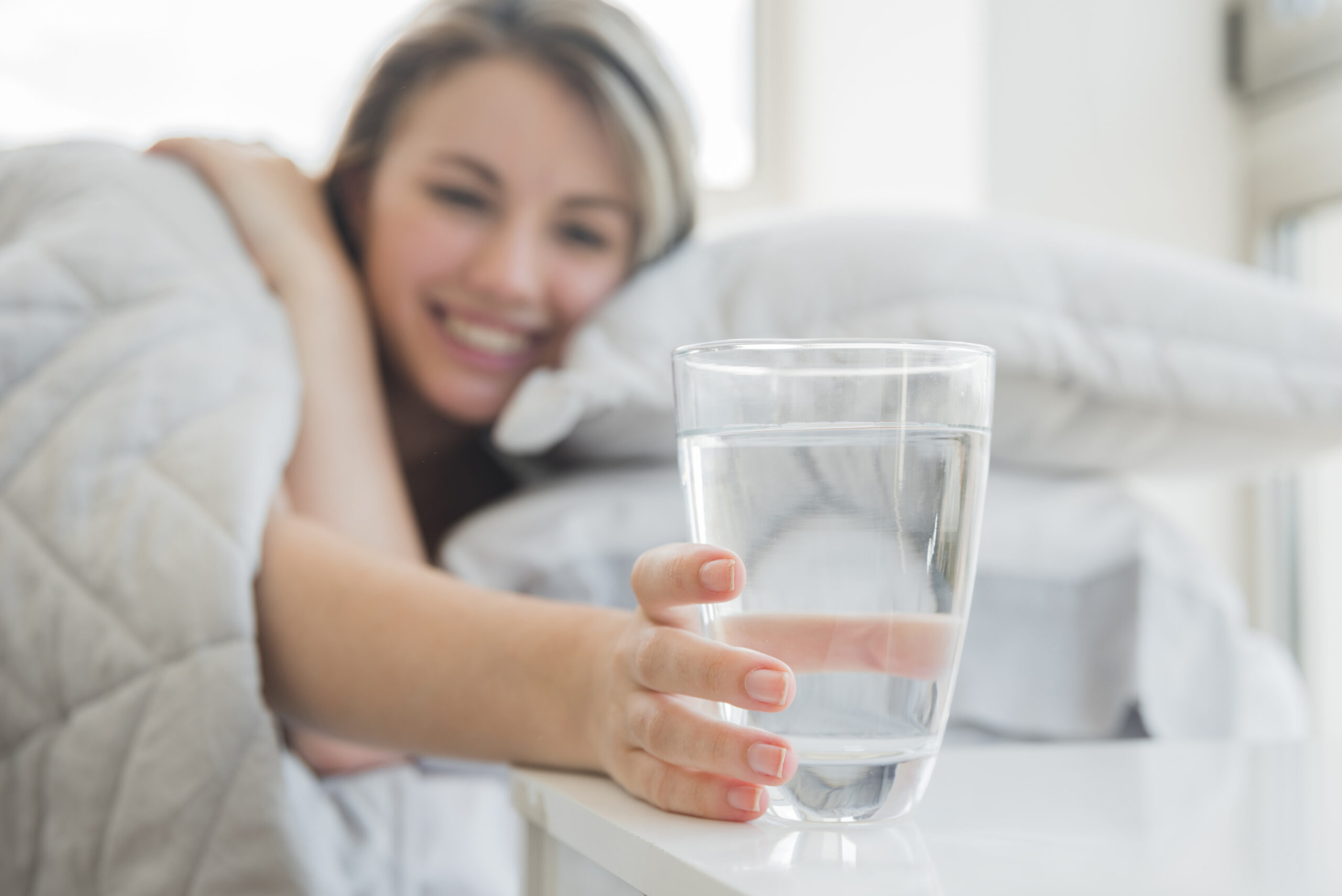 10 Benefits of Drinking Hot Water in the Morning for Better Health 5 blonde girl taking glass water scaled