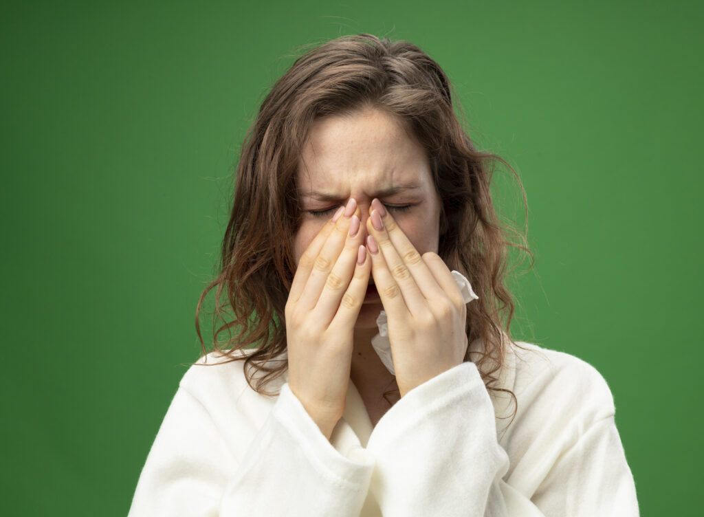 10 Benefits of Drinking Hot Water in the Morning for Better Health 9 sneezy young ill girl wearing white robe holding hands nose isolated green