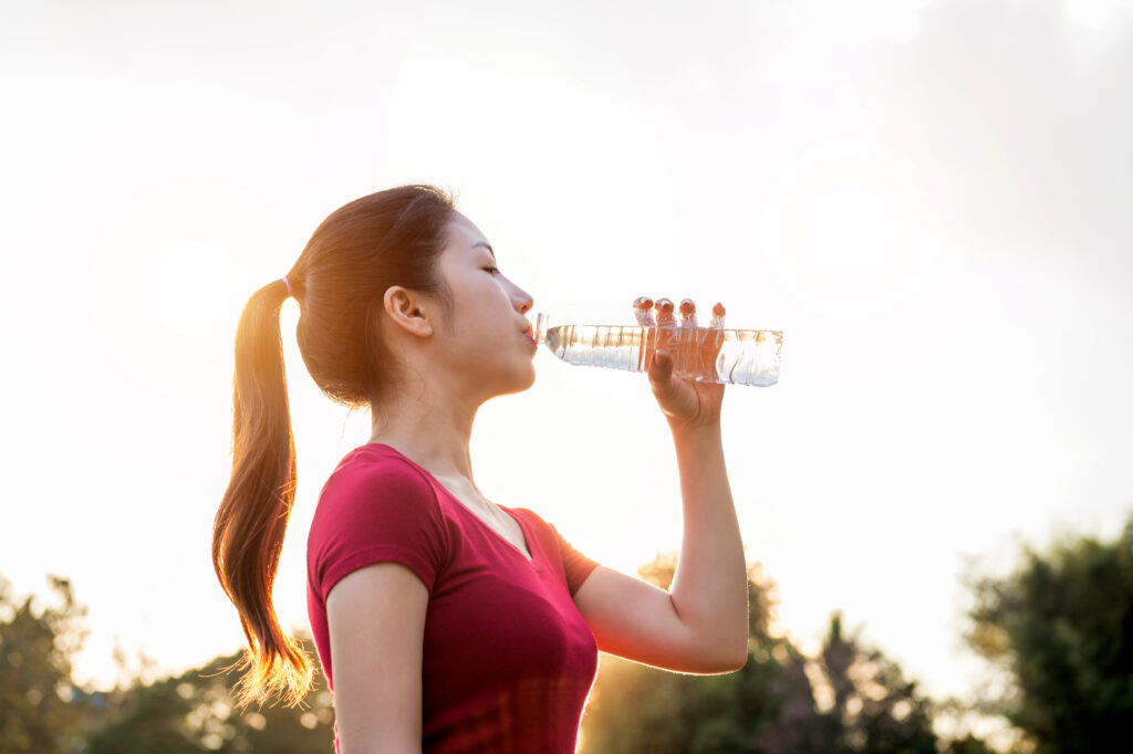 10 Benefits of Drinking Hot Water in the Morning for Better Health 11 sporty woman drinking water sunlight