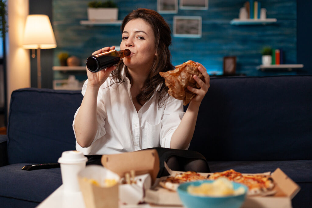 Is Skipping Dinner Good for Weight Loss? 4 portrait woman looking into camera fastfood lunch meal order relaxing sofa